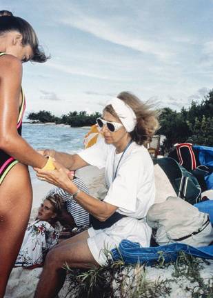 Director Creates Filmic Ode to Legendary Sports Illustrated Swimsuit Editor Editor Jule Campbell adjusts a bracelet on model Kathy Ireland's wrist during a <i>Sports Illustrated</i> Swimsuit Issue shoot in Saint Vincent and the Grenadines in the fall of 1989. Model Judit Masco can be seen in the background.