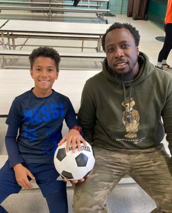 Fourth grader Reis Powell with Michael Onimole, PS 9 site supervisor and soccer coach. Photo courtesy of Neil Fitzgerald, Arts and Athletics