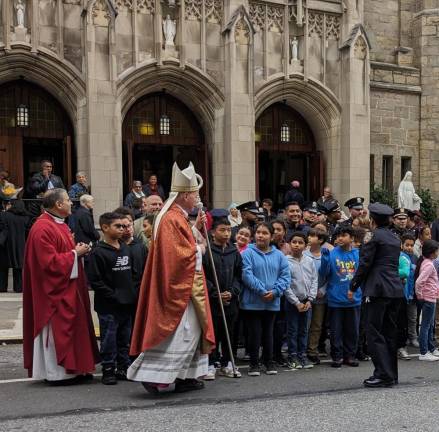 Bishop Edward Whalen greets students from P.S. 48, now called Michael Buczek Elementary, and St. Elizabeth’s School outside St. Elizabeth Church following the memorial Mass for Officers Buczek and Christopher Hoban. Photo: Brian Berger