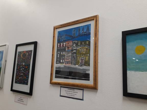 New artist Stu Beinhachev said he put his favorite buildings on top in his painting (center) because you can do anything in art. Photo: Karen Camela Watson
