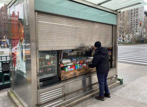 <b>Sadik Topia locks up the newsstand he has operated for 23 years on the corner of W. 79th St. The city is trying to level nearly $60,000 in fines that would effectively force him out of business. Locals are rallying to his defense.</b> Photo: Michael Oreskes