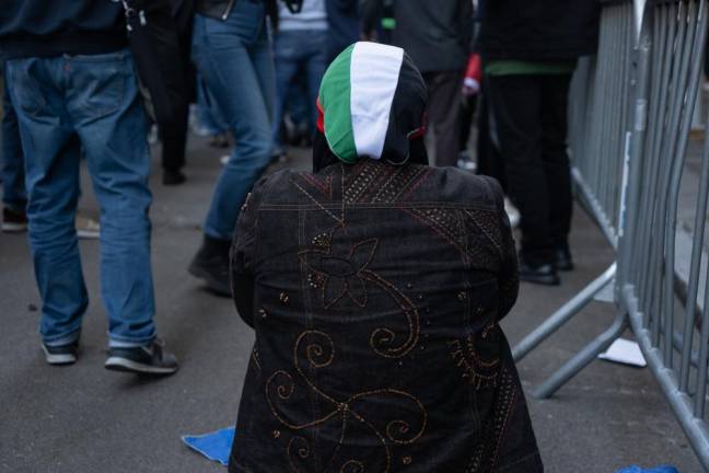 A Muslim woman praying amidst the protest.