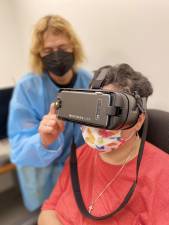 The author with a patient using the IrisVision assistive technology. Photo courtesy of Lighthouse Guild