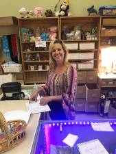 <b>Ilze Thielmann at the check in counter of a shop run by Team TLC NYC where asylum seekers can “shop” among rows of dontated clothes in the newly transformed boutique that was once the reading room of the Seventh Day Adventists.</b> Photo: Keith J. Kelly