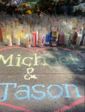 Candles and flowers on the sidewalk where Jason Negron and Michael Saint-Hilaire were killed on May 15.