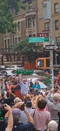 McCourt family members pull the covering from the official Malachy McCourt Lane sign on West 93rd Street and West End Ave. while another holds up an official replica of the sign.