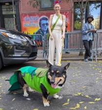 Smiling dog mom and caterpillar dog outside a Joe Strummer mural on East 6th Street during the Tompkins Square Park Dog Halloween parade in the East Village on Oct. 19.