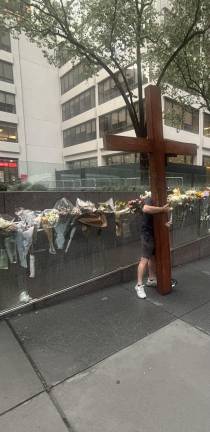 Dan Beazley said he drove in a pickup truck with the huge wooden cross from his home outside Detroit to comfort mourners at the makeshift memorial outside 345 Park Ave., where a gunman shot and killed four innocent victims on July 28.
