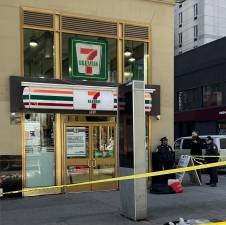 A man was shot and killed during an argument at a 7/11 on Eighth Avenue on the morning of Feb. 12, cops say. Shopping bags believed to belong to the victim can be seen on the sidewalk outside the store, which remained a crime scene hours after the shooting.