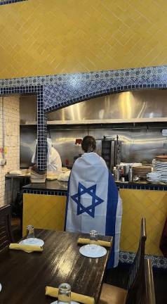 Galaza Halabi wearing her country’s flag the day after she claimed her employee’s were harassed by pro-Palestinian protestors once they realized the shop was run by Israelis.