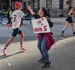 Fan along First Ave. Offers to Slap a High Five with Marathoners. Photo: Brian Berger