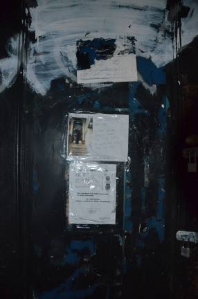 A handwritten sign on the front door of 44 West 73rd Street warns people to be on the lookout for John Kojo Zi. Photo by Daniel Fitzsimmons.