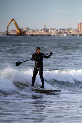Construction continued as the backdrop for surfers at Rockaway Beach through December.