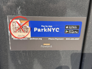 Pictured is a QR code sticker partially removed from a ParkNYC meter. The NYC DOT has urged drivers not to scan QR codes and to report any suspicious stickers.