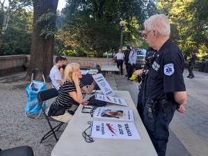 Julie Harvey (seated), who said she was injured in a collision by a speeding biker in Central Park, speaks to Central Park Medical Unit about bicycle concerns.
