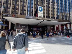 Travelers walking into the Seventh Avenue entrance to NYC’s Penn Station