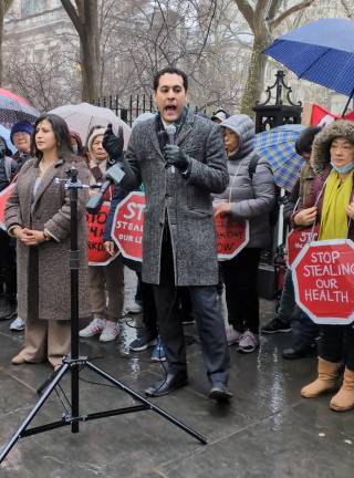 Gloved Christopher Marte speaking on behalf of “No More 24!” law to protect home health aide workers.