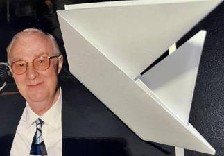 The author’s father and an origami sailboat. Photo courtesy of Mona Finston