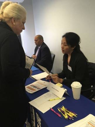 Carmen Cuyar Alvarez shares her resume with a representative from the University Settlement nonprofit. Photo: Megan Conn