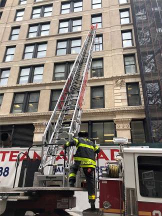 <b>Firefighters from modern day FDNY Truck 20 raise their automated ladder to the sixth floor at the building that still stands so bystanders can visualize how the ladders in 1911 could not the eighth and ninth floors, where workers were trapped.</b> Photo: Keith J. Kelly