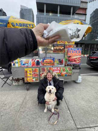Our photographer captures Maui, a 9-year-old Golden Retriever, with owner Sabrina Lanz, as he is about to devour a free hotdog from a street vendor.