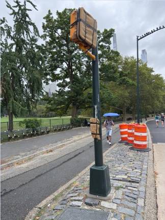 Traffic signals that would halt traffic and allow pedestrians to cross safely are wrapped in burlap and inoperable as part of a controversial pilot program that is redesigning the loop road in Central Park.