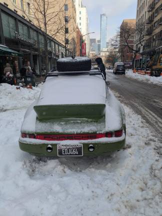 Porsche with Montana license plate, tire on roof on University Place, on day after storm on Jan. 26, 2026.
