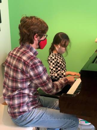 Shay Slusky with a piano student. Photo courtesy of West Amadeus Music Studio