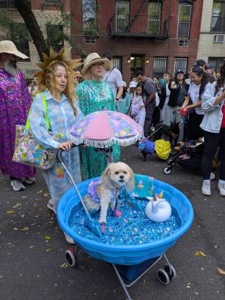 A sun goddess of the Lower East Side pushes her dog in a wading pool.