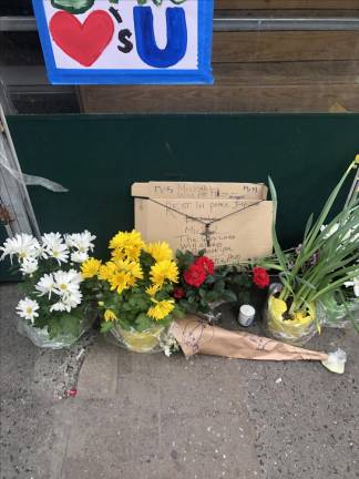 A memorial grows to the slain deli worker from Korea, identified only as “Michael” outside Doana Deli on the corner of E. 81st and Third Ave. following after he was gunned down in cold blood on March 4 by an assailant dressed in a haz-mat suit. Photo: Keith J. Kelly