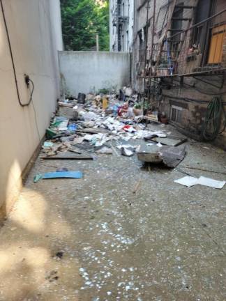 The backyard of the apartment located on 104 Sullivan Street with the concrete covered in shattered glass and debris. Photo: SoHo guy