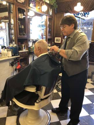 Héctor Masner puts the finishing touches on a haircut at York Barber Shop. An An old-school aesthetic prevails at the Lexington Avenue shop. Photo: Shoshy Ciment