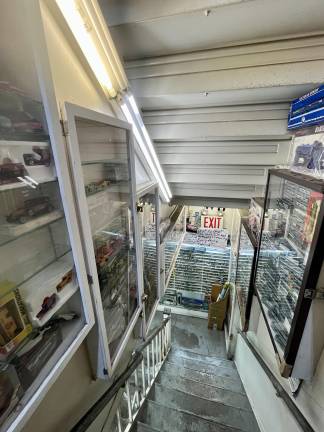 On the way down the stairs to the store, display cabinets fill the stairwell with merchandise. No wasted wall space is evident.