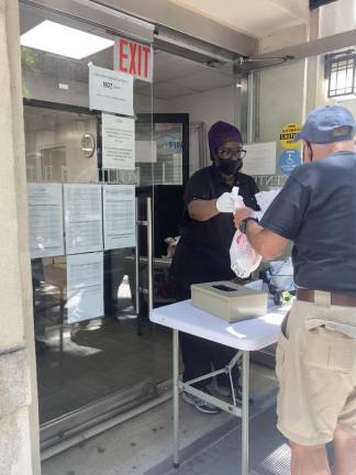 Latoya Scott of Project FIND hands Mark Brown a grab-and-go lunch. Photo: Ella Gotbaum
