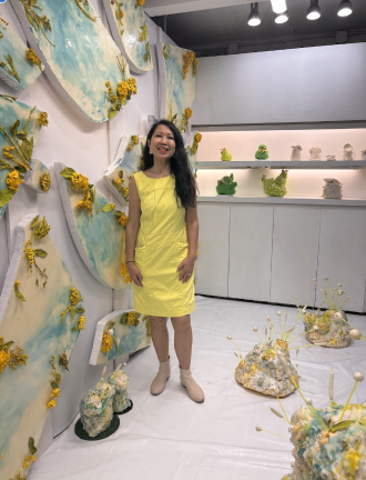 Cecile Chong poses with her installation <i>Chicken Little – Líneas de Falla / Fault Lines</i> at Whitebox Portable in the Times Square transit hub.