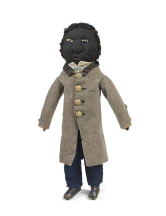Doll in gentleman’s top coat, 1860-70. Milton, MA. Mixed fabrics, leather, brass, glass. Deborah Neff Collection. Photo: Ellen McDermott Photography