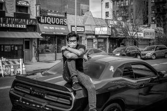 “Defiant” - A man waiting outside a family bodega for his turn.