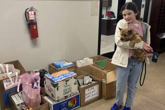 Lauren Lavin, 14, with her dog, Bear, and some of the non-perishables collected from UWS residents for The Beresford Annual Food Drive.