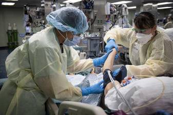 <b> Hospitalman Yenifer Gutierrez, left, and Hospitalman Brashea Ojeda check a patients blood pressure in the intensive care unit aboard the hospital ship USNS Comfort during the worse days of COVID. in NYC in 2020.</b> Photo: U.S. Navy photo by Mass Communication Specialist 2nd Class Sara Eshleman