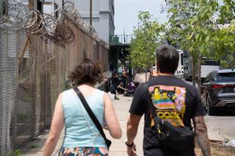 Pedestrians heading toward a homeless encampment on West 45th Street that occupied the entire sidewalk, forcing people to venture into the street to get around it.