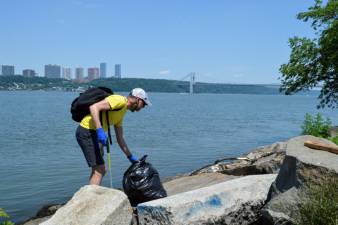 Drew Marlar, chapter leader of Trash Hero New York, collecting trash on the water’s edge. Photo: Abigail Gruskin