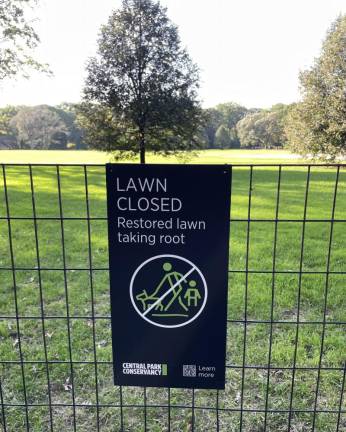 A sign on the fence surrounding the Great Lawn indicates that the area is closed for restoration.