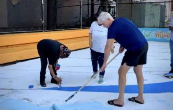 Bill Ackman, the hedge fund billionaire who plunked down between $6 million to $7 million to renovate the playground at the public housing complex, helps paint the refurbished basketball court.
