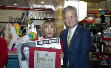 Ellen Hart, owner of Ellen’s Stardust Diner and a former Miss Subways (1959), poses with Manhattan Borough President Brad Hoylman-Sigal holding her original Miss Subways poster and a Proclamation in celebration of the Miss Subways reunion and her 85th birthday.