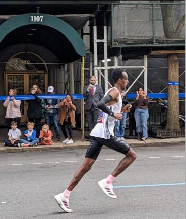 Tamirat Tola from Ethiopia set a new men’s course record, seen here heading up First Ave. Photo: Brian Berger