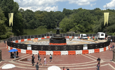 Bethesda Fountain from atop Bethesda Terrace, featuring the beginnings of construction and a handful of construction workers.