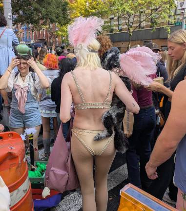 Pink feathers on a showgirl and her showdog nearing the parade route.