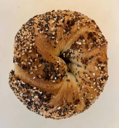 A top down look at a New Absolute everything bagel. The swirls look like it is a hand rolled bagel, there was no skimping on seeds and it seems well-baked.