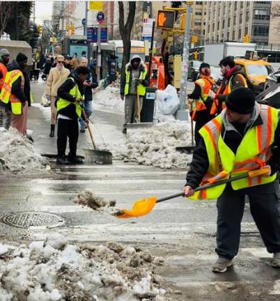 Workers clearing crosswalks for pedestrians on Feb. 25.