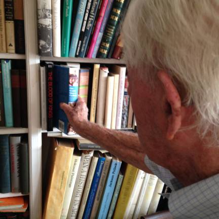 George Braziller, at a bookshelf full of his titles